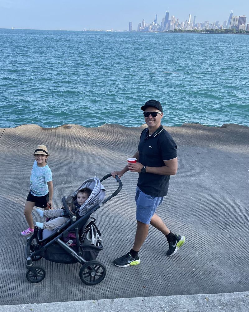 Dom pushing a stroller along the Chicago lakefront with his kids