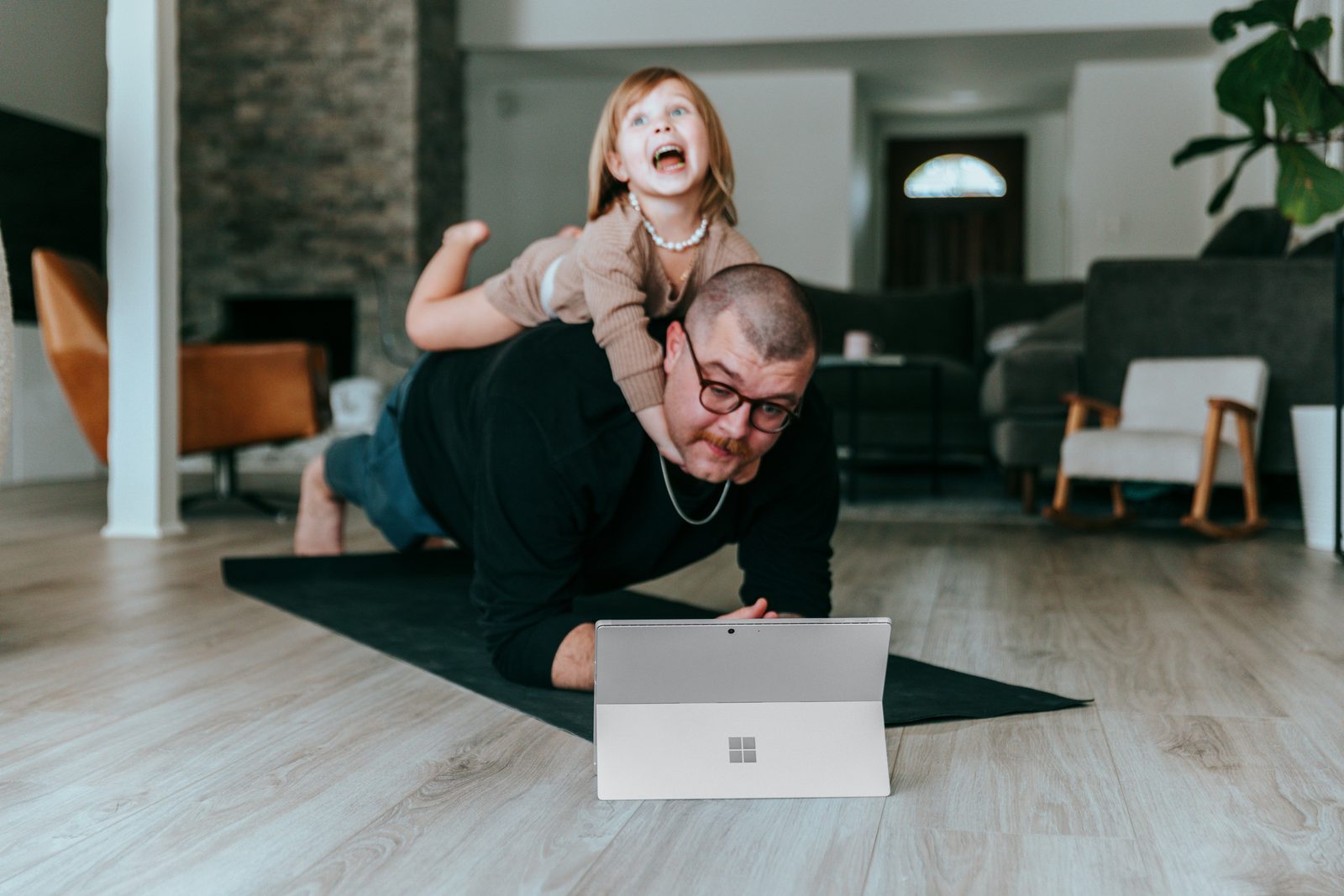 Dad attempting a workout while his kid climbs on his back