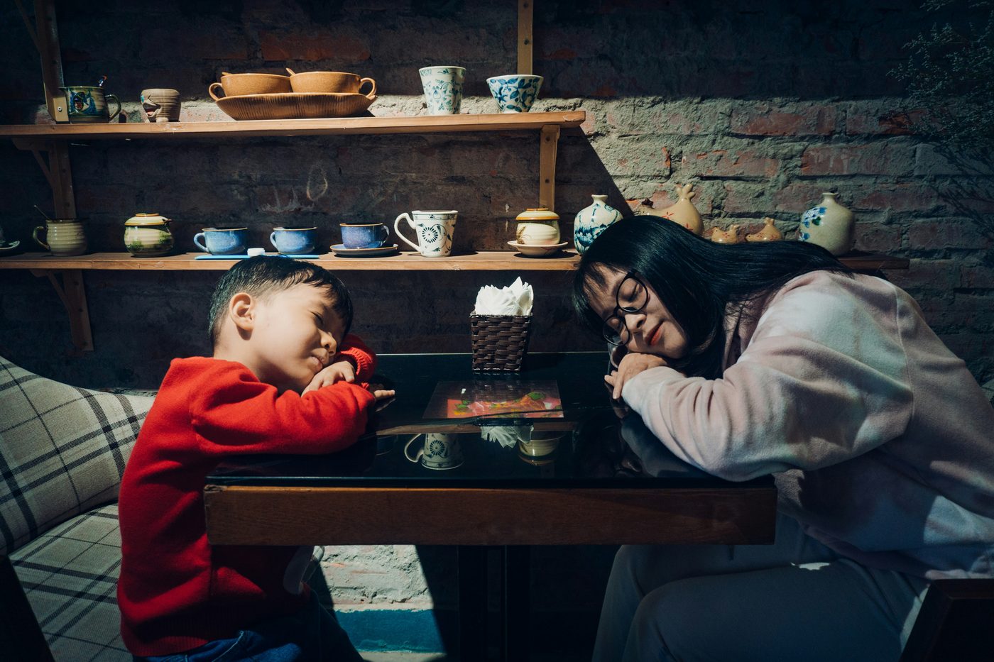 Mom and kid asleep at a café table — the before picture